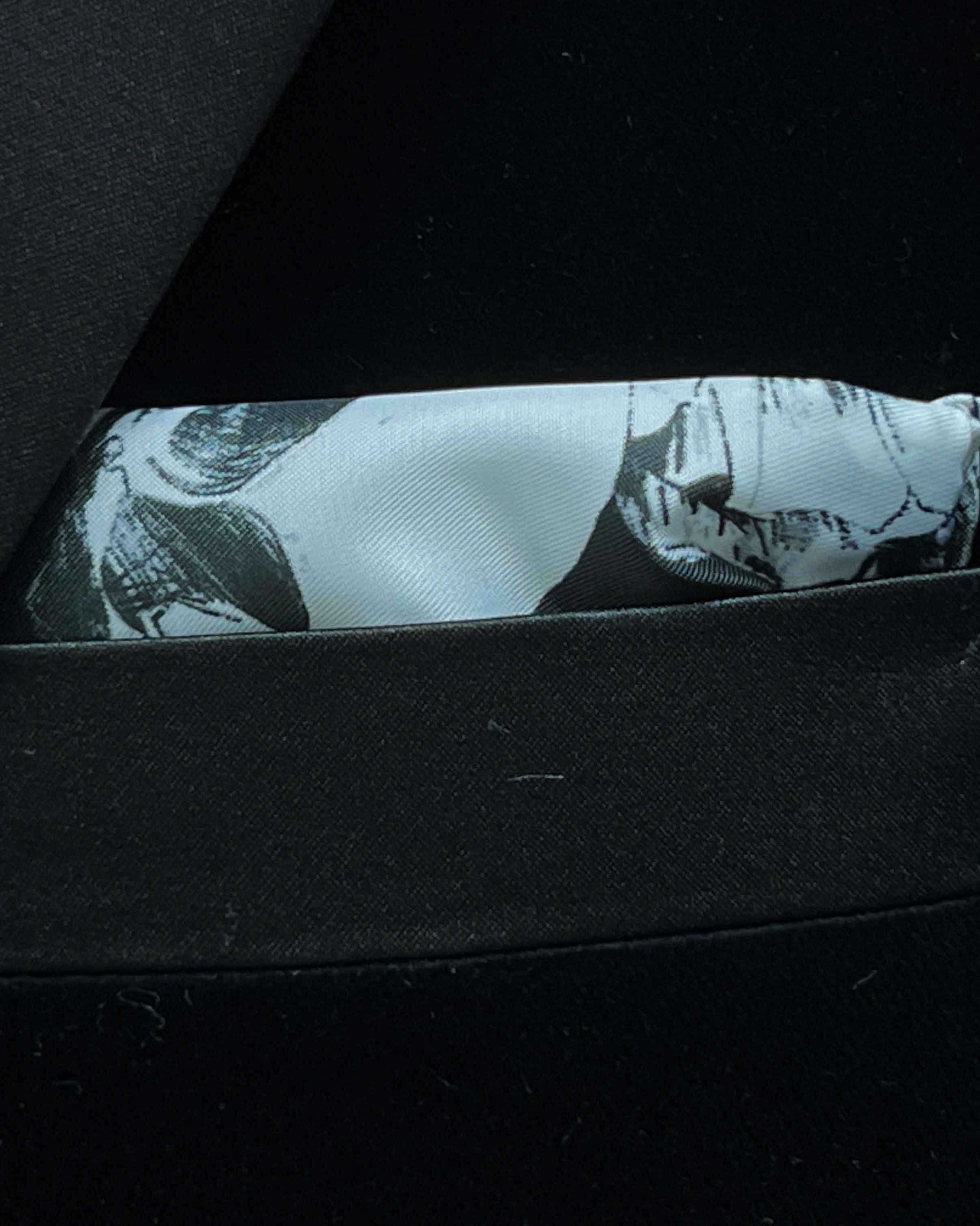 Breast pocket of black silk velvet formalwear tuxedo jacket with built-in pocket square holder and hand-finished edges