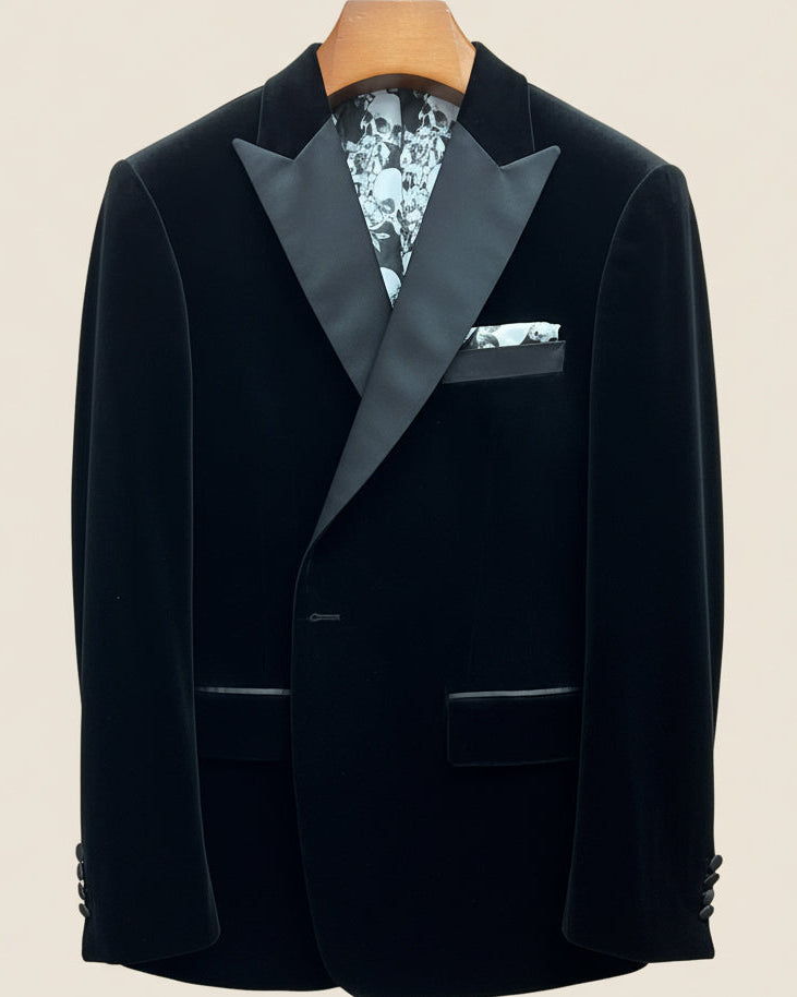 Close-up view of black silk velvet formalwear tuxedo jacket showing satin peak lapel with hand-finished stitching detail