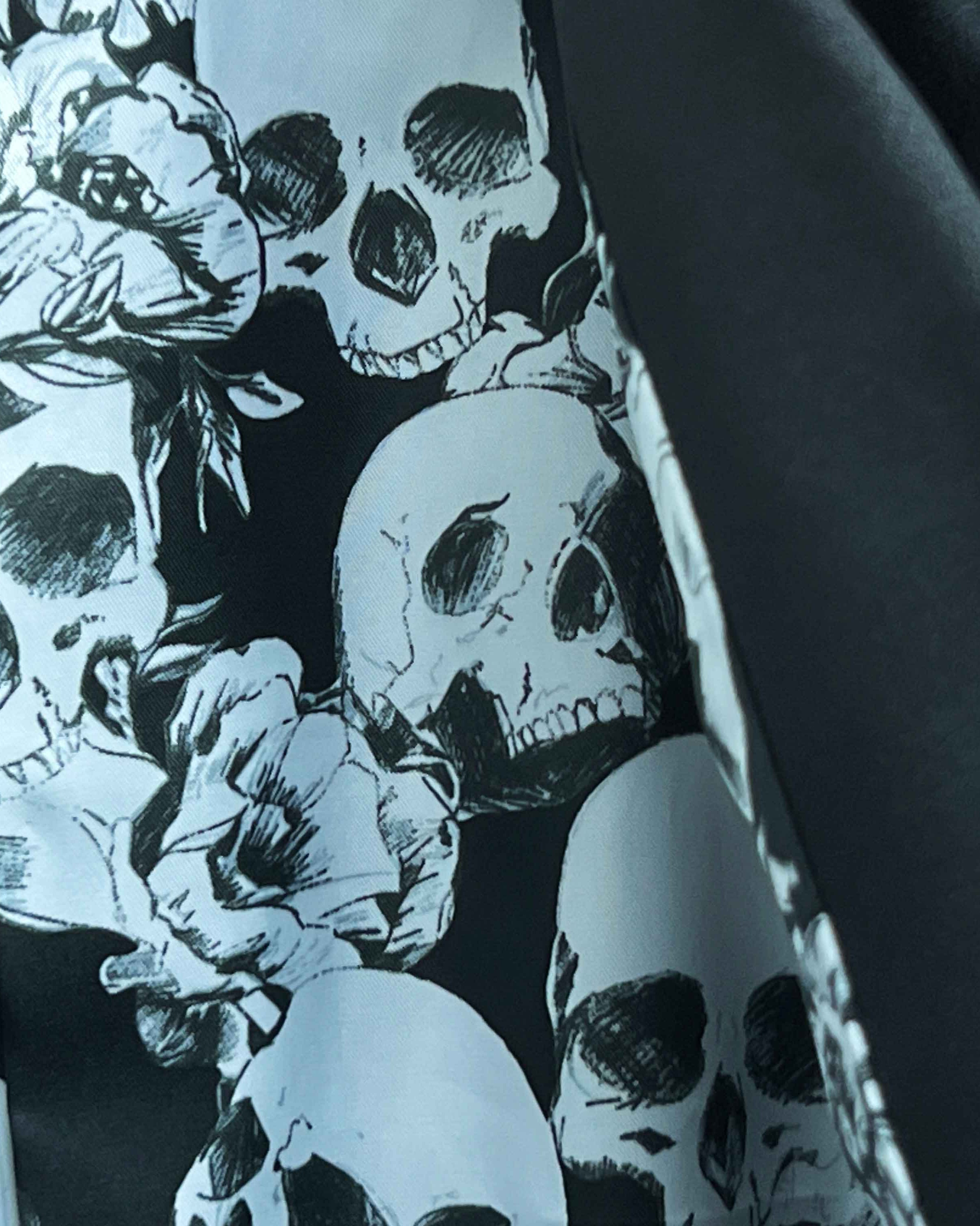 Colorful flash lining detail visible at jacket cuffs and vents in black and white skull pattern