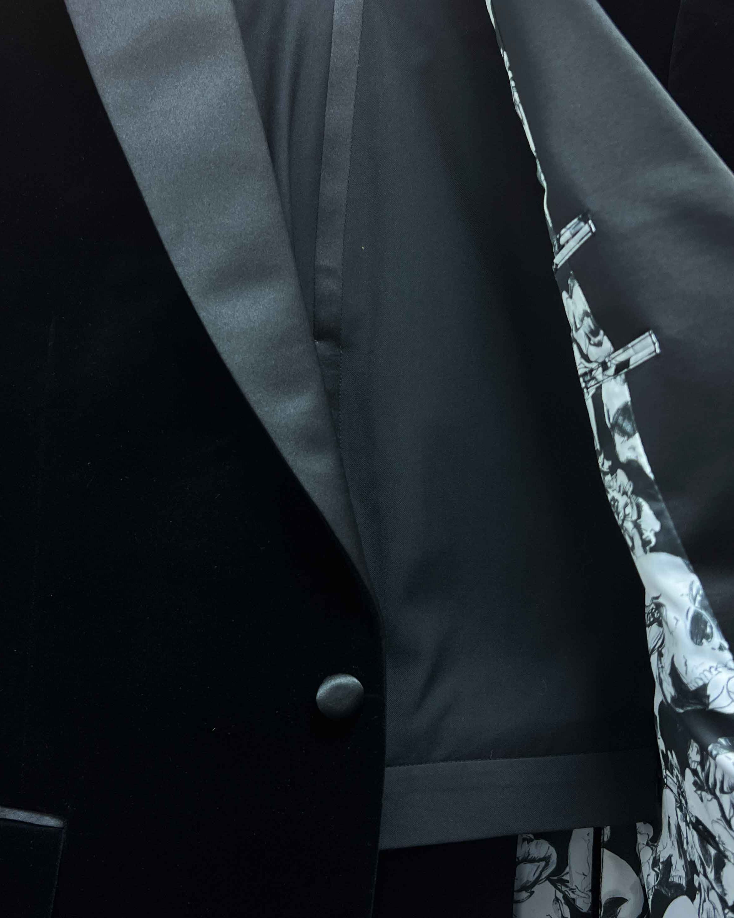 Complete two-piece black silk velvet formalwear tuxedo displayed on hanger showing jacket and trousers with satin trimming