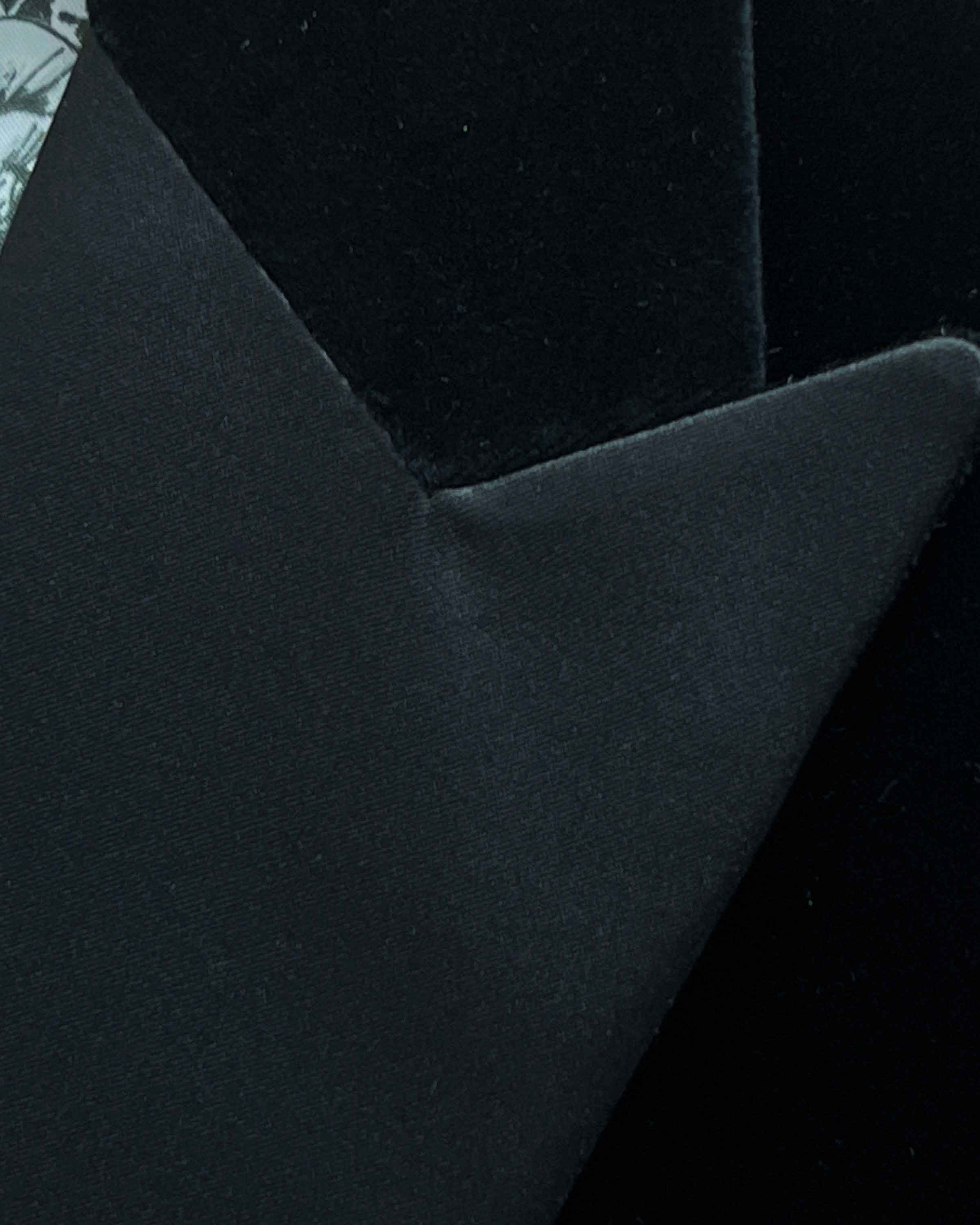 Satin peak lapel detail on black silk velvet formalwear tuxedo jacket showing hand pick stitching and silk satin trimming