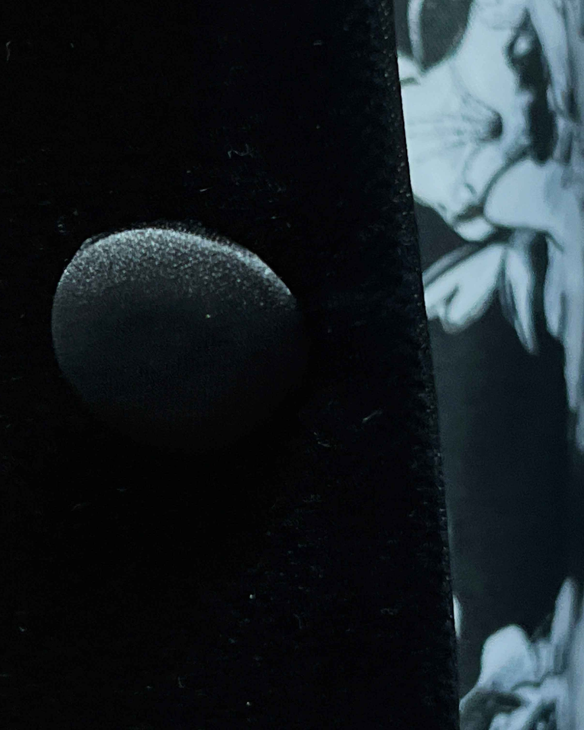 Close-up of black silk satin covered buttons on black silk velvet formalwear tuxedo jacket showing lustrous finish