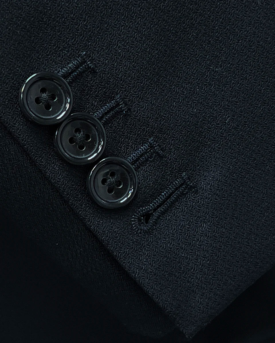 Detail shot of functional buttonholes on the sleeve of a black Westwood Hart suit jacket