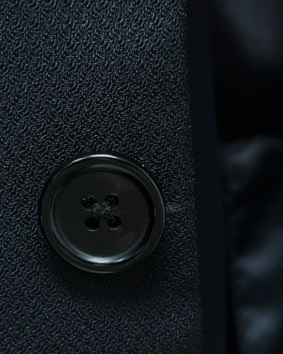 Detailed view of black horn buttons on a Westwood Hart self-textured jacquard suit jacket