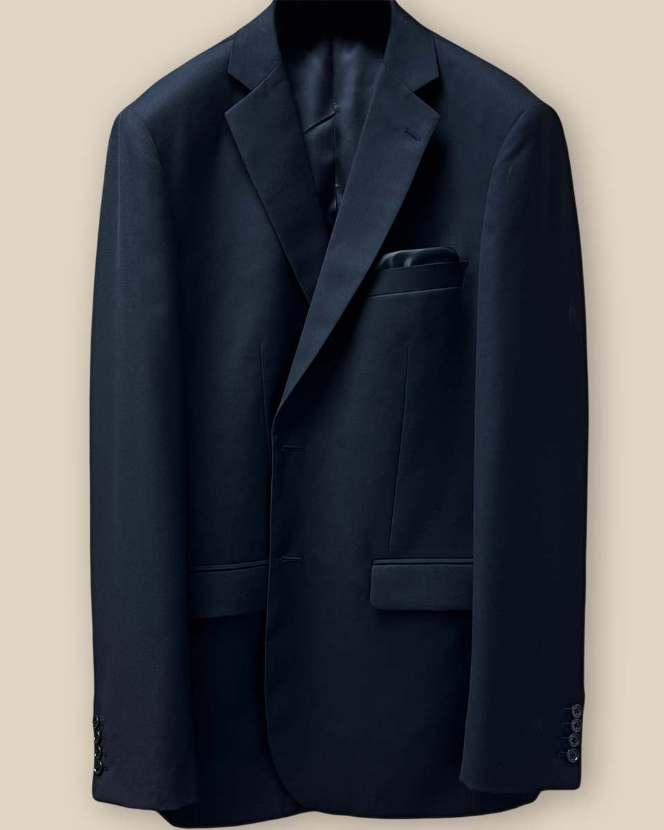 Close-up of black self-textured jacquard suit jacket showing buttonhole detail on the front panel