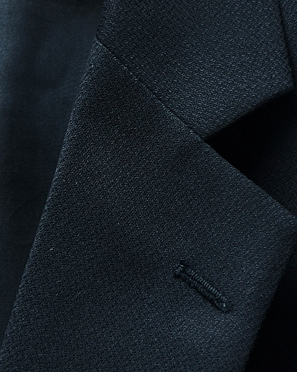 Detail view of the notch lapel on a black self-textured jacquard Westwood Hart suit jacket