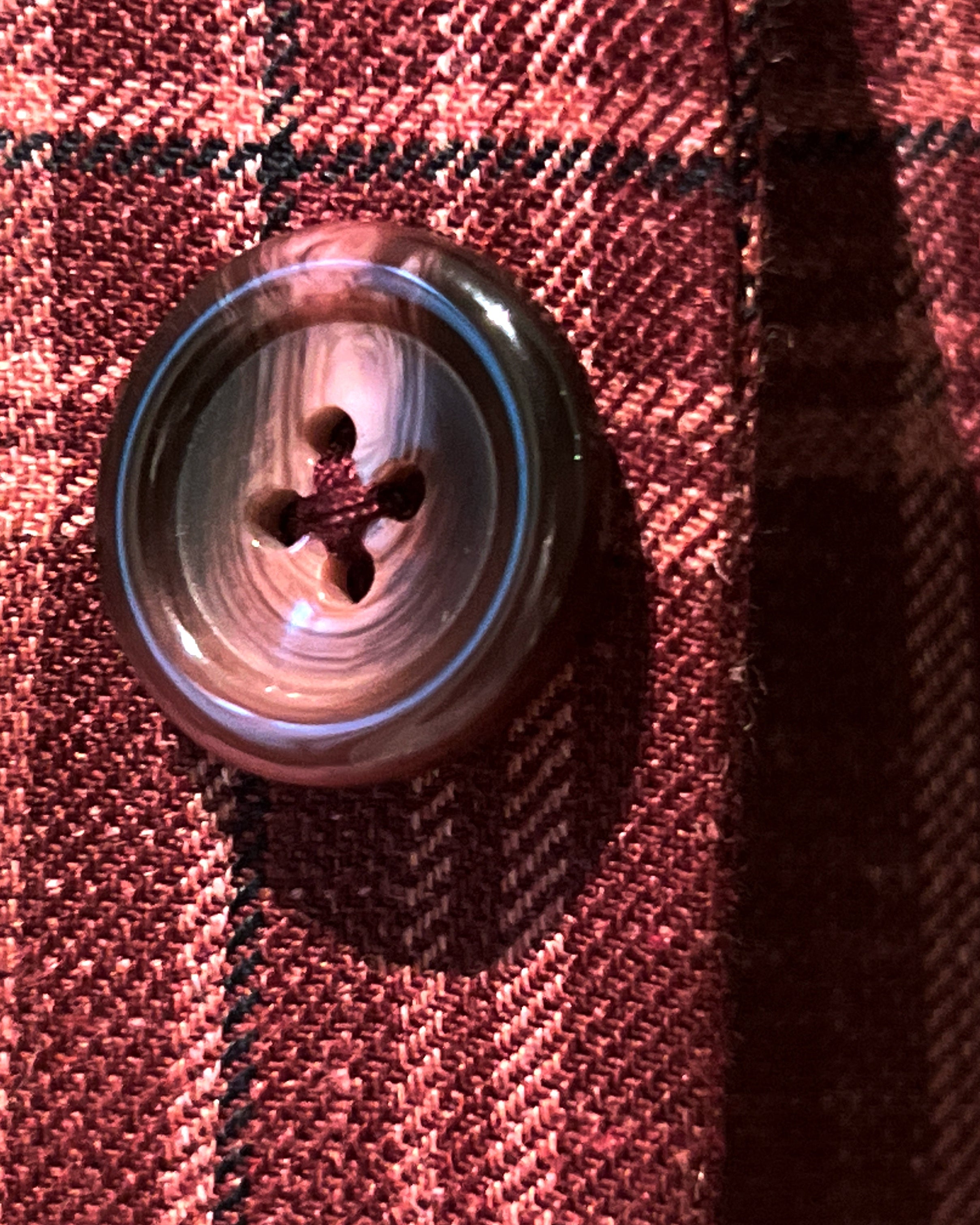Close-up of burgundy marble buttons on burgundy plaid sport coat showing natural marble-like patterns