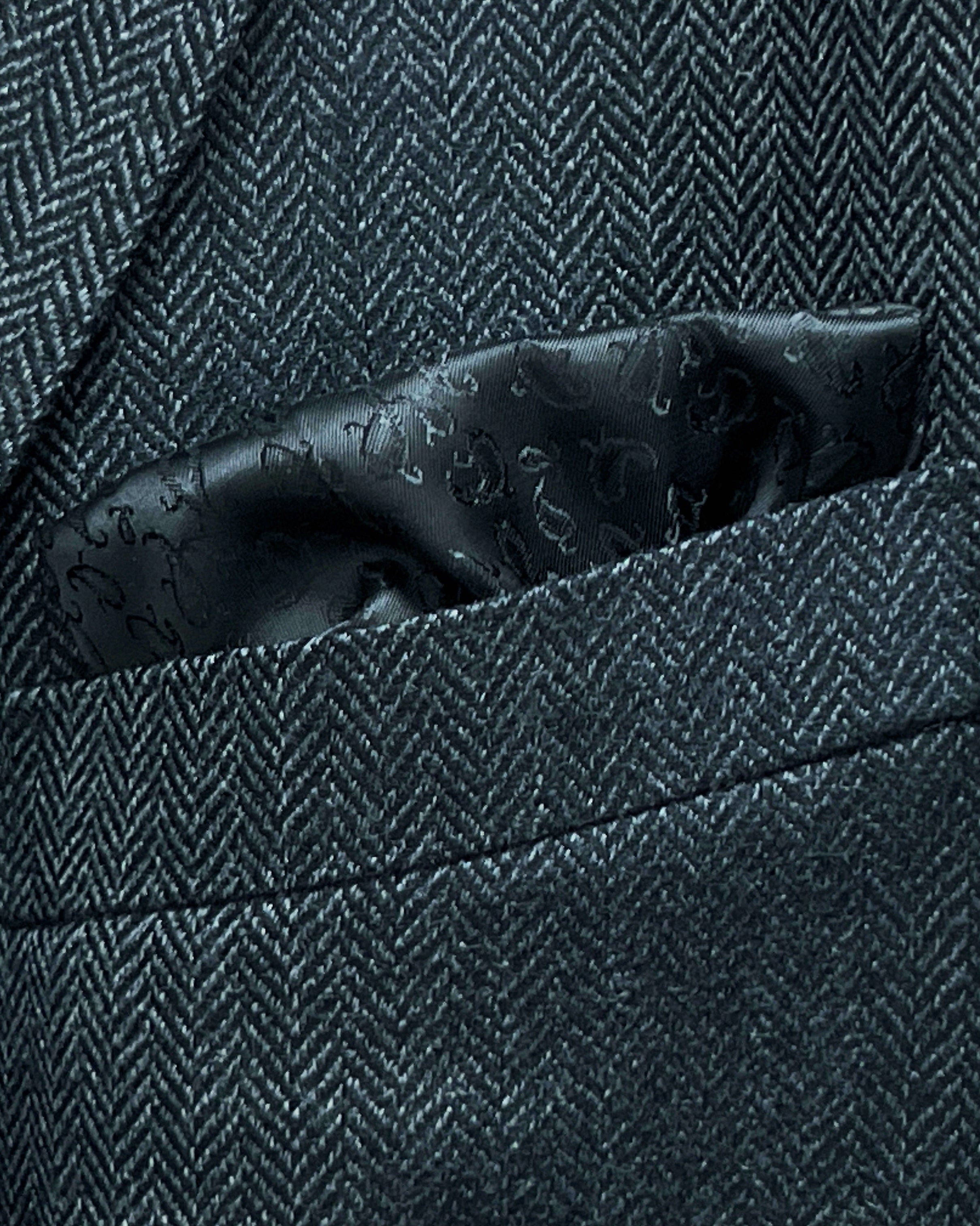 Breast pocket of charcoal grey herringbone sport coat with built-in pocket square holder and hand-finished edges