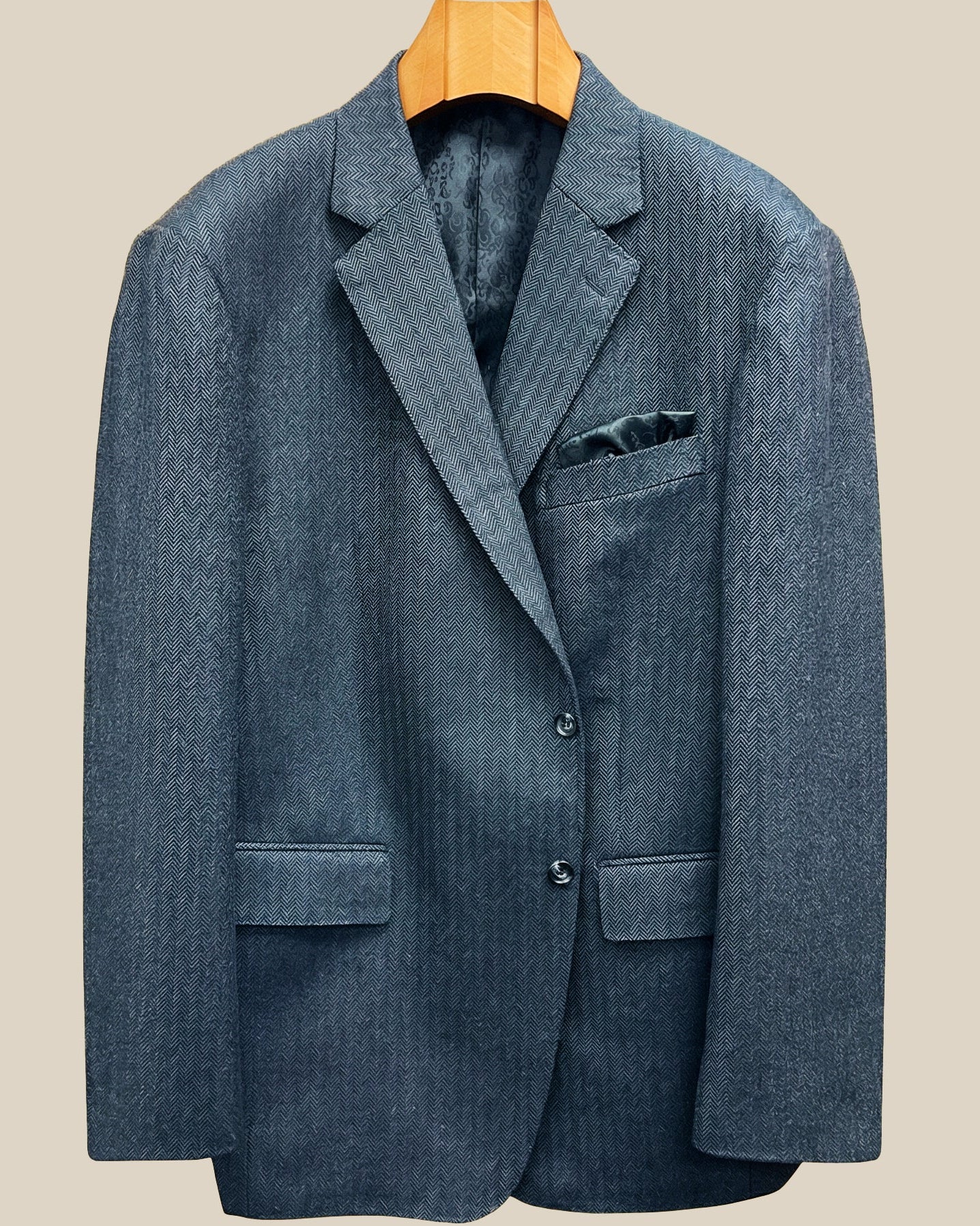 Front button panel of charcoal grey herringbone sport coat featuring charcoal horn buttons with light grey marbling and hand pick stitching
