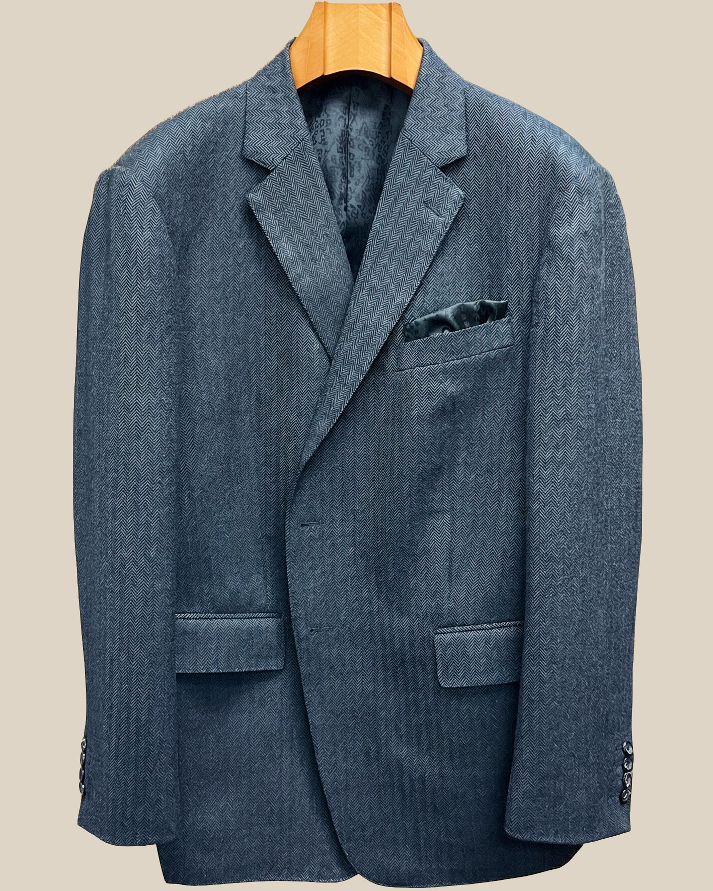 Close-up view of charcoal grey herringbone sport coat showing contrast edge pick stitching detail on buttonhole panel