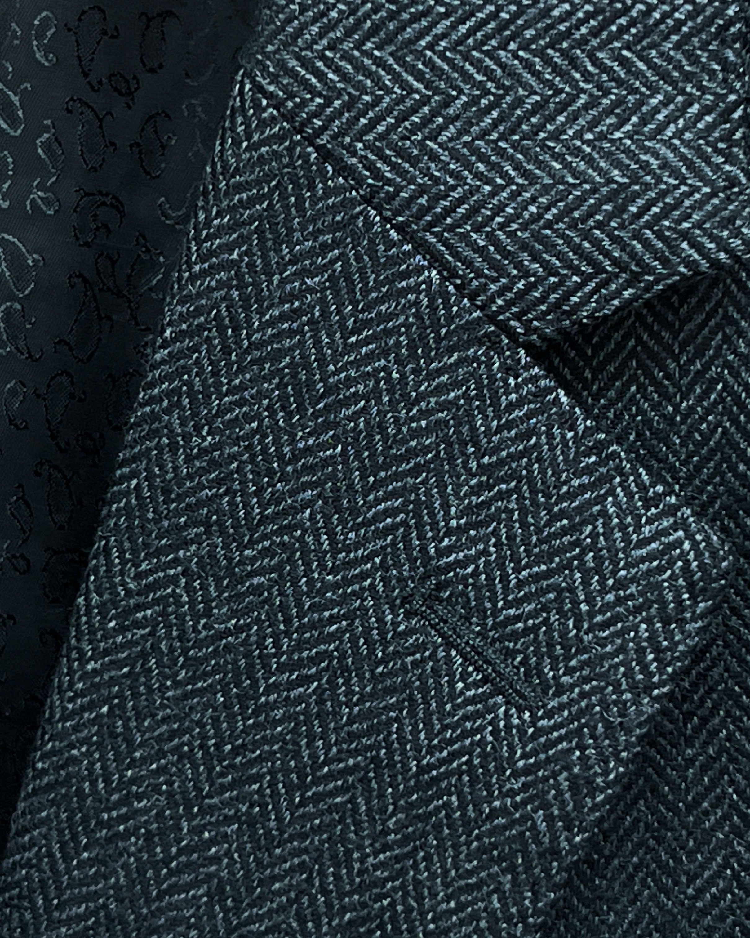 Classic notch lapel detail on charcoal grey herringbone sport coat showing hand pick stitching and herringbone weave pattern