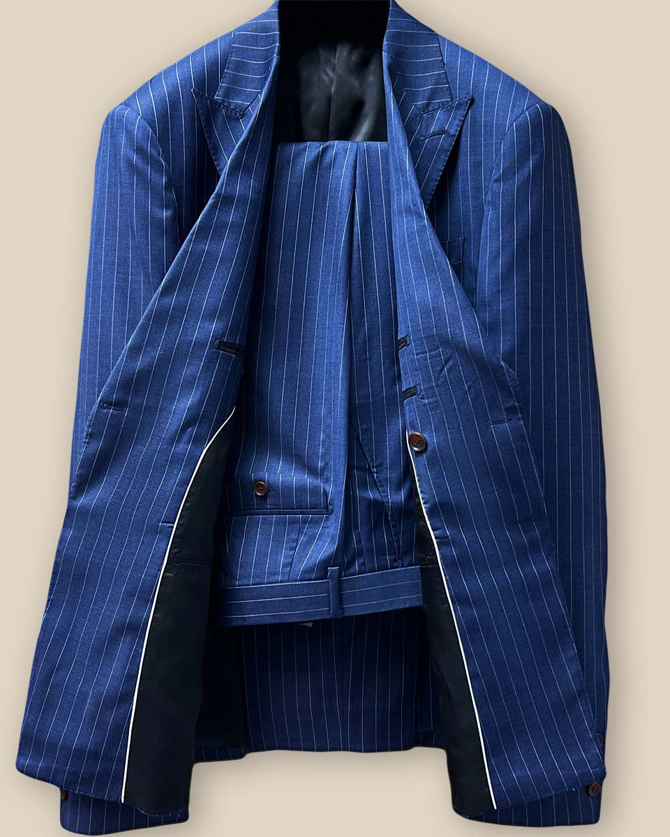 Front view of double-breasted dark blue pinstripe suit, showcasing peak lapels and slanting flap pockets