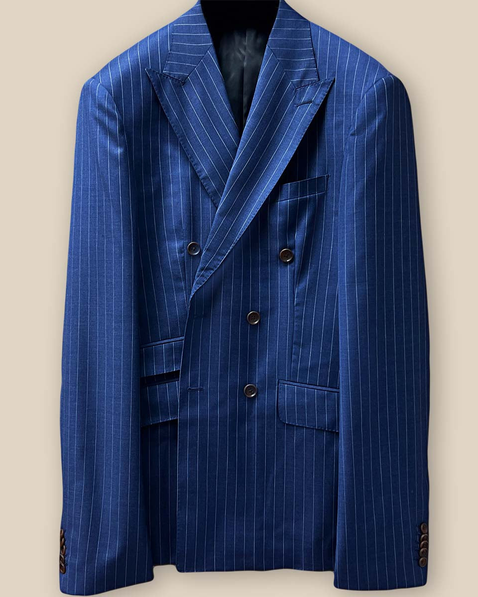 Close-up of dark blue pinstripe suit jacket showing detailed Milanese buttonhole on lapel