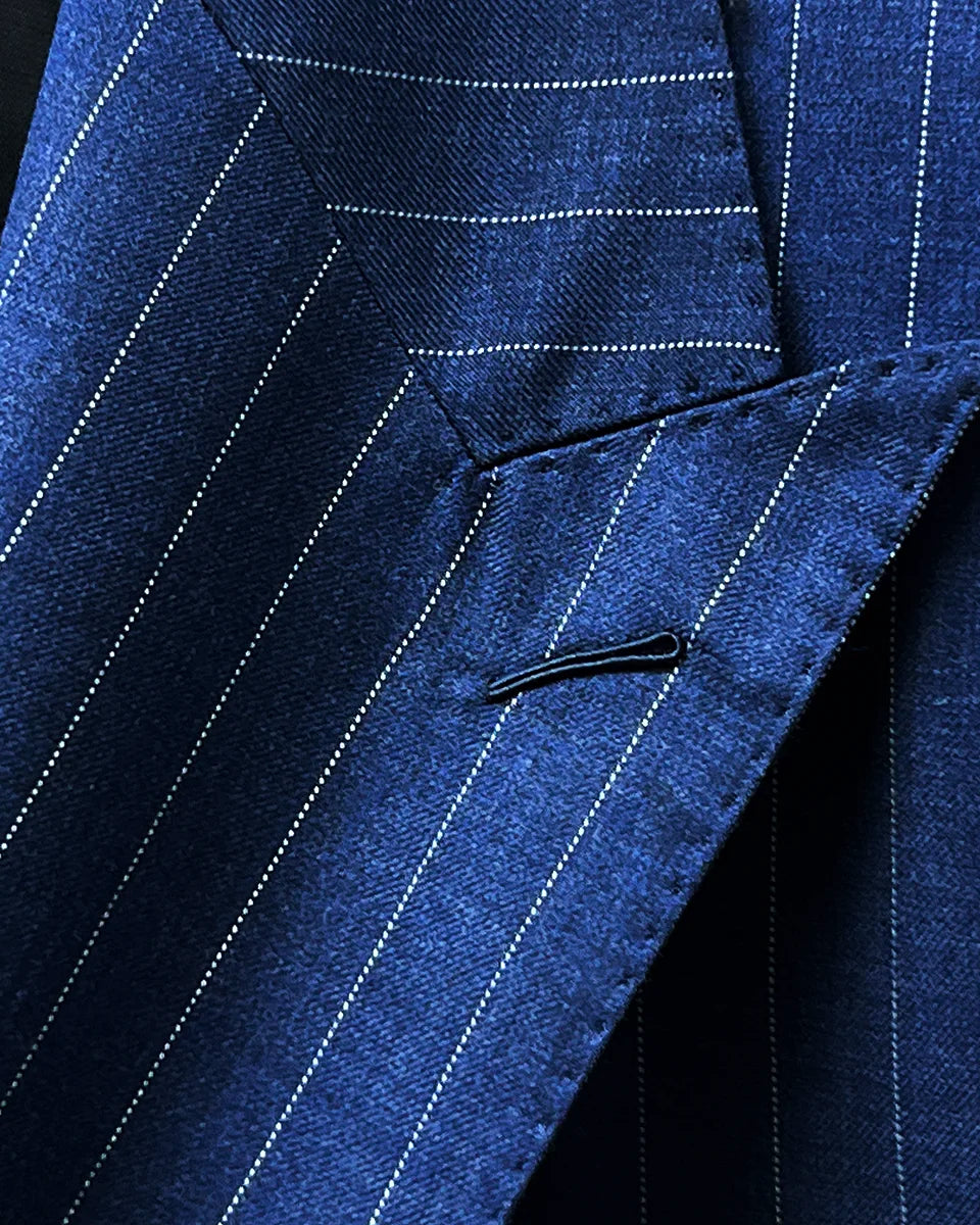 Close-up of the suit's peak lapel, showcasing the sharp angles and fine stitching