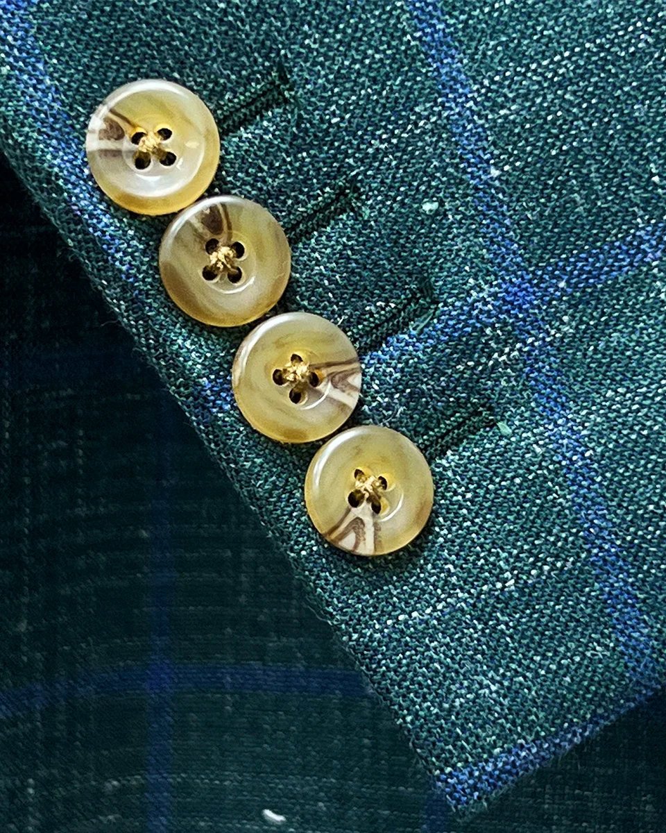 Detail of functional sleeve buttonholes on dark green Westwood Hart windowpane sport coat, demonstrating quality tailoring