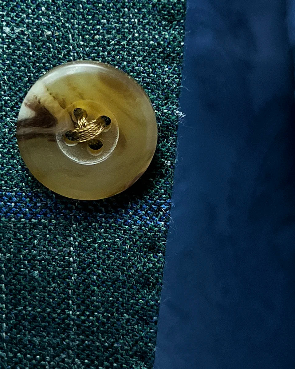 Close-up of tan horn marble buttons on dark green Westwood Hart windowpane sport coat, highlighting their unique texture and color
