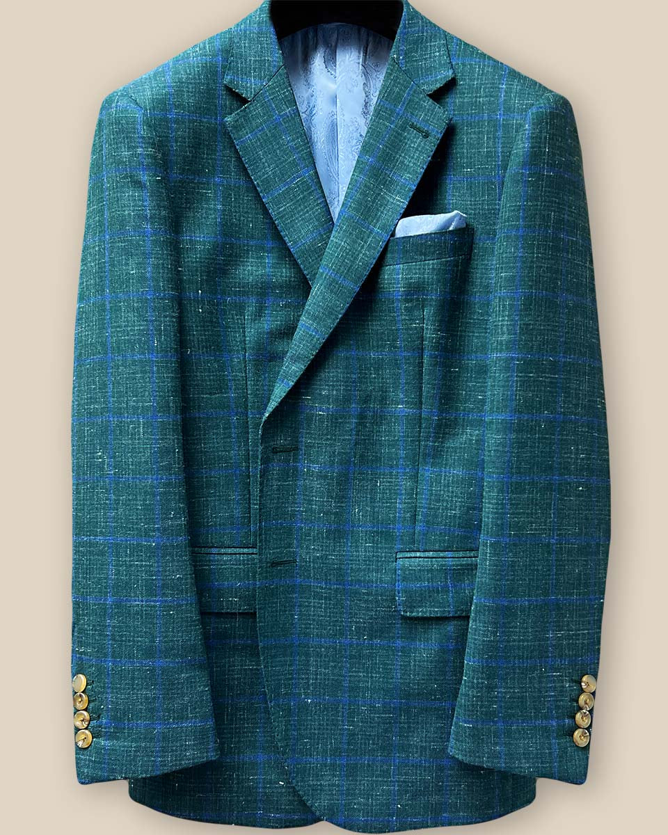 Close-up of dark green Westwood Hart windowpane sport coat buttonhole panel, showcasing fine stitching and tan horn marble buttons