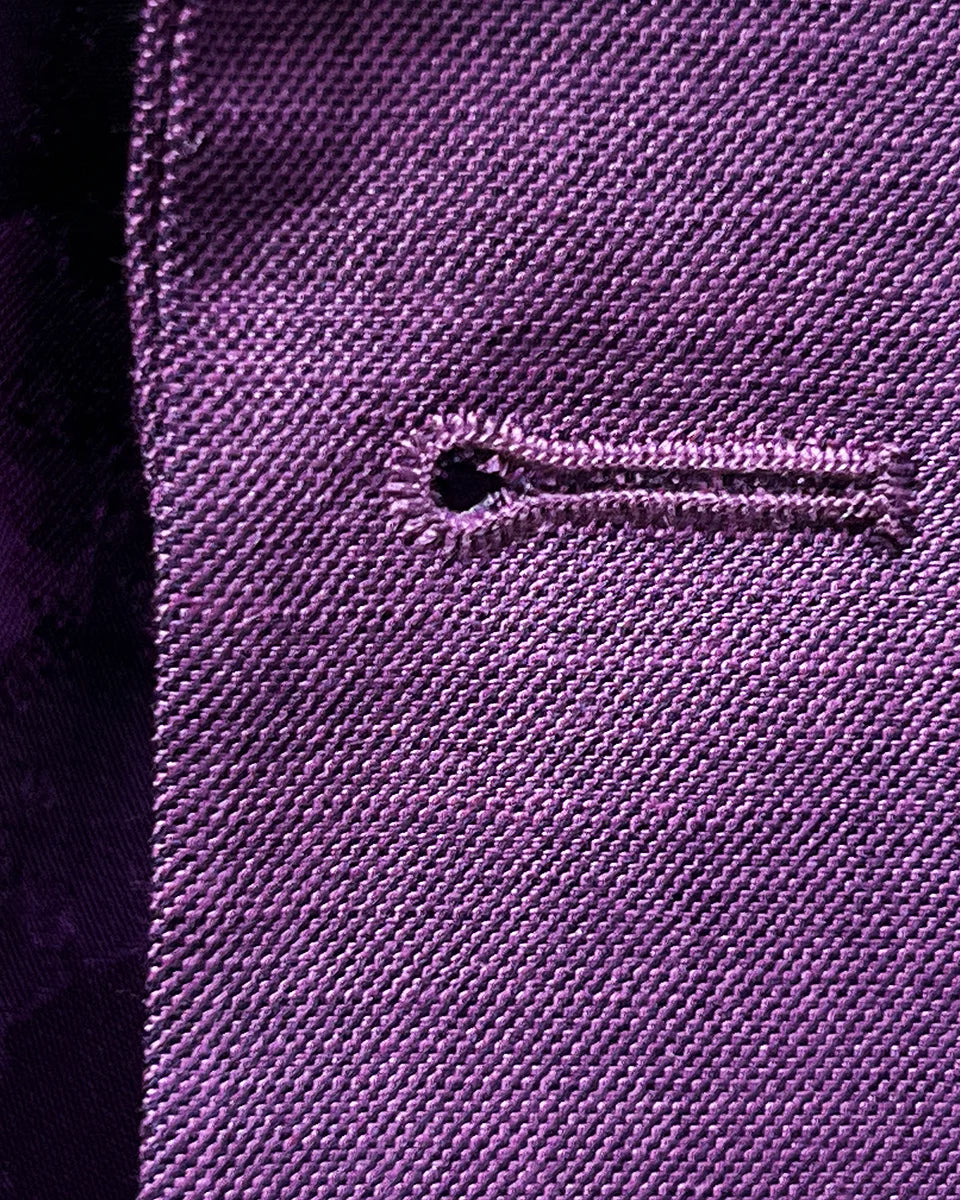Detailed macro view of precision lilac contrast buttonhole stitching showcasing artisan craftsmanship and attention to detail