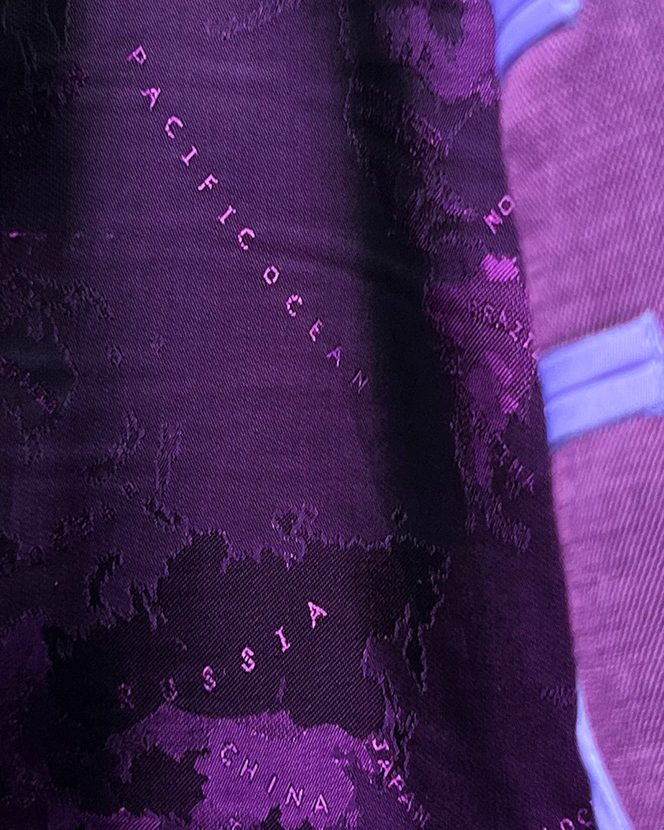Stylish flash lining details visible at cuffs and edges complementing the purple world map interior lining design