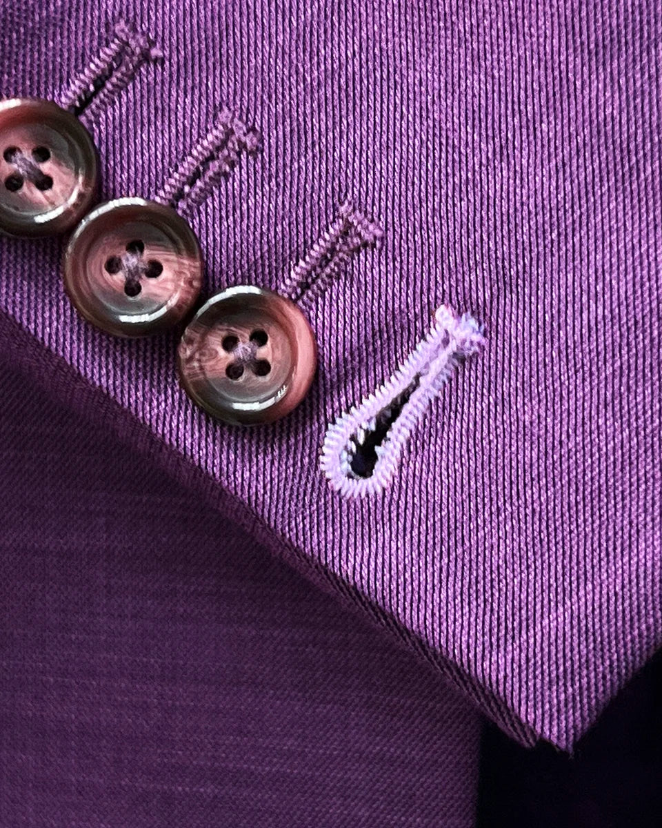 Working sleeve buttonholes with lilac contrast stitching demonstrating authentic custom tailoring and functional design elements