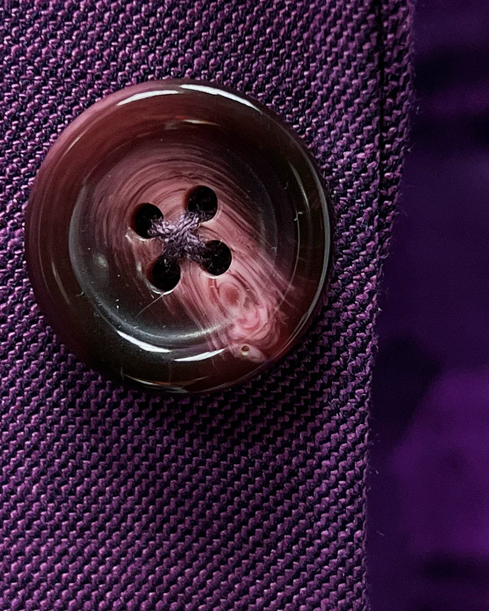 Premium mulberry horn buttons displaying natural marbled texture and rich coloring that complements the purple fabric beautifully