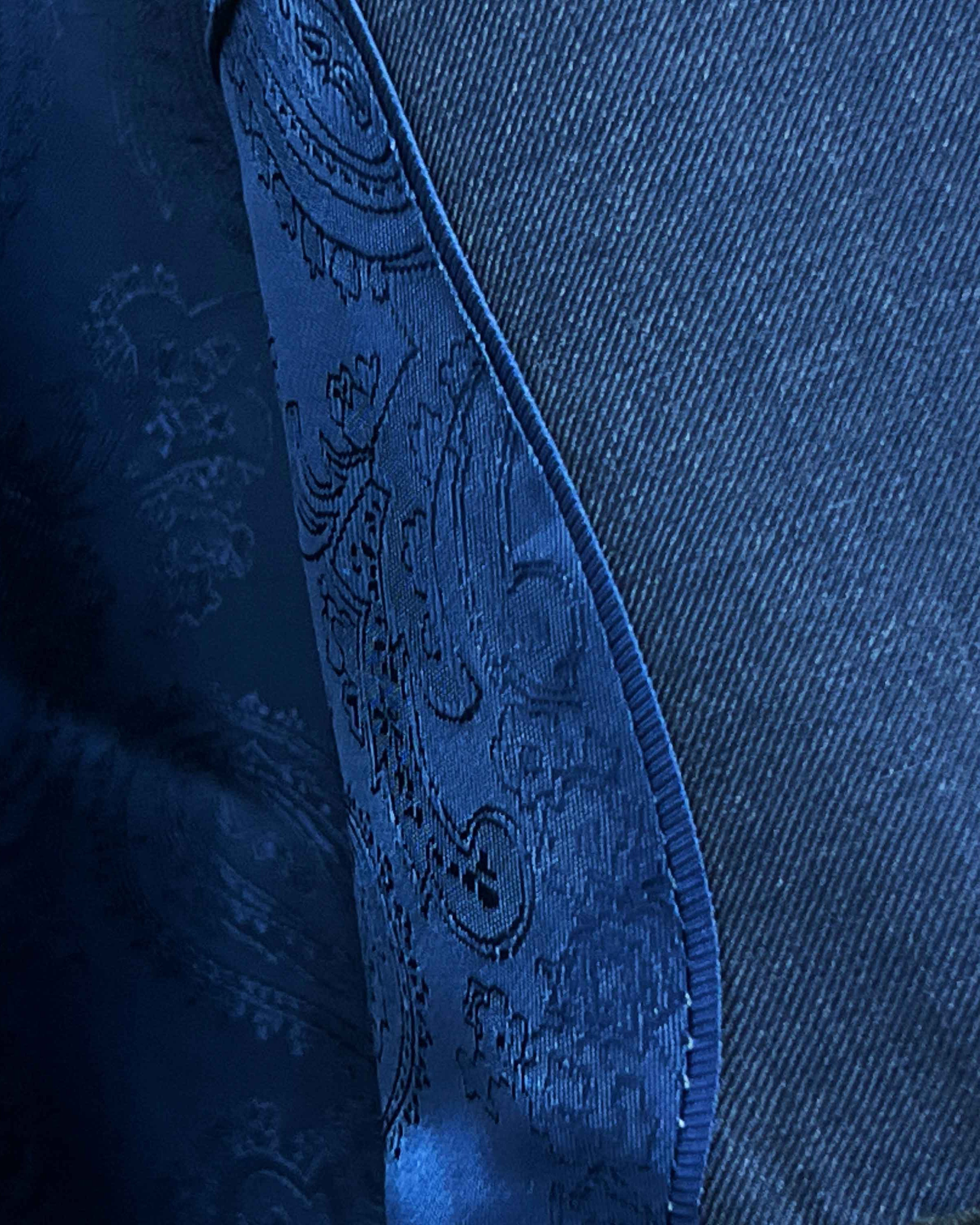 Close-up of a blue denim fabric with intricate stitching detail
