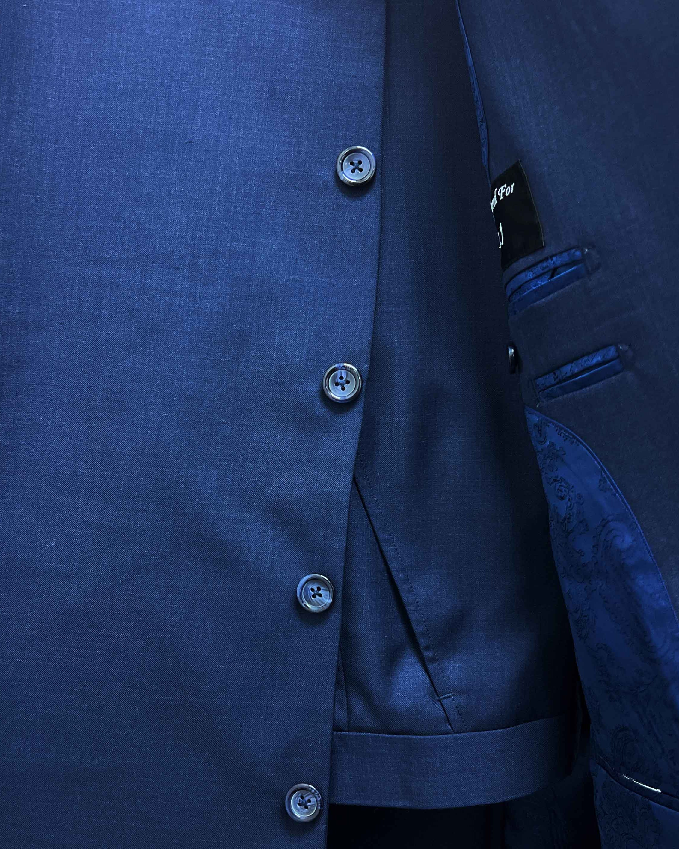 Close-up of a blue suit jacket with buttons and a brand label.