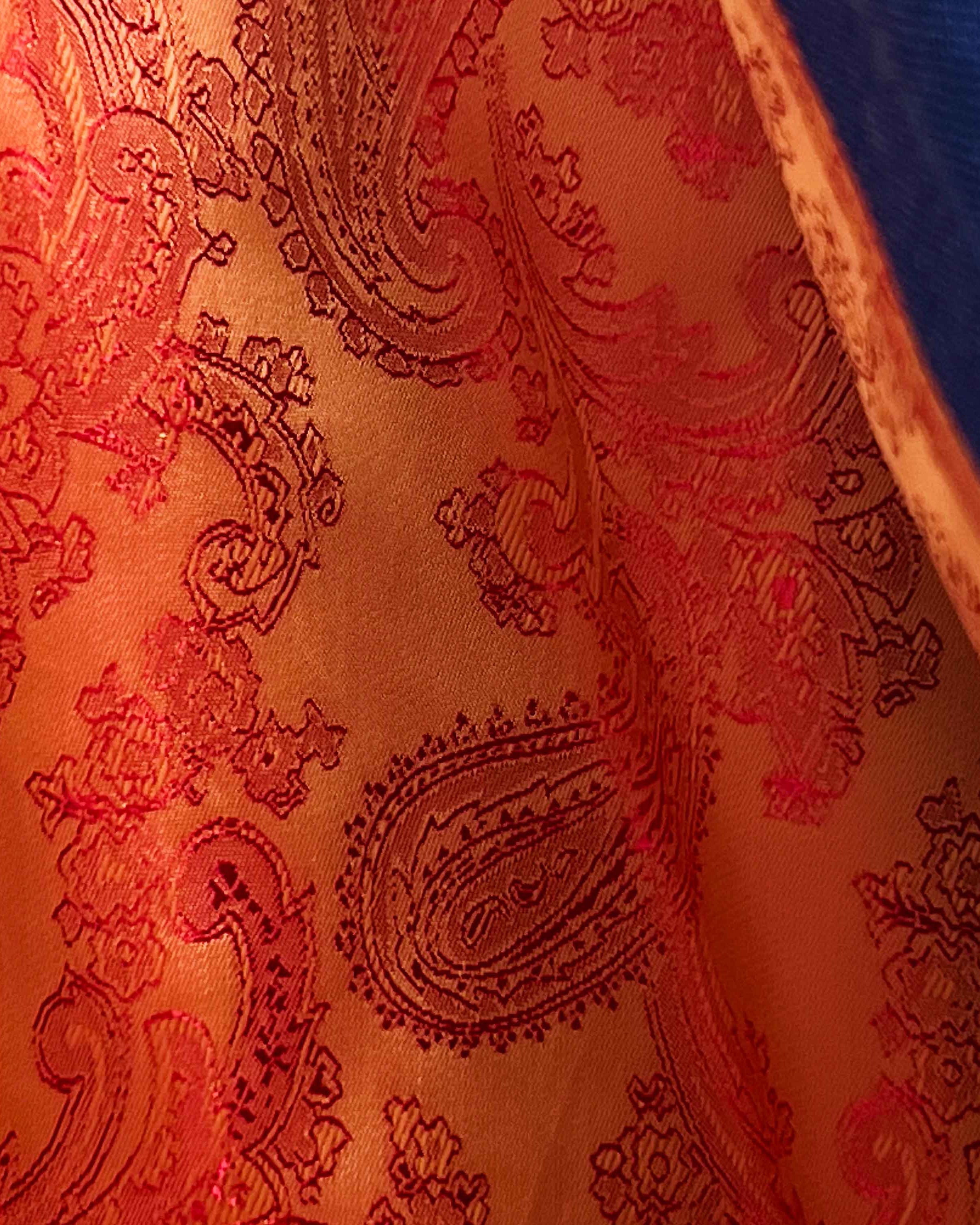 Colorful flash lining detail visible at jacket cuffs and vents in orange paisley jacquard pattern