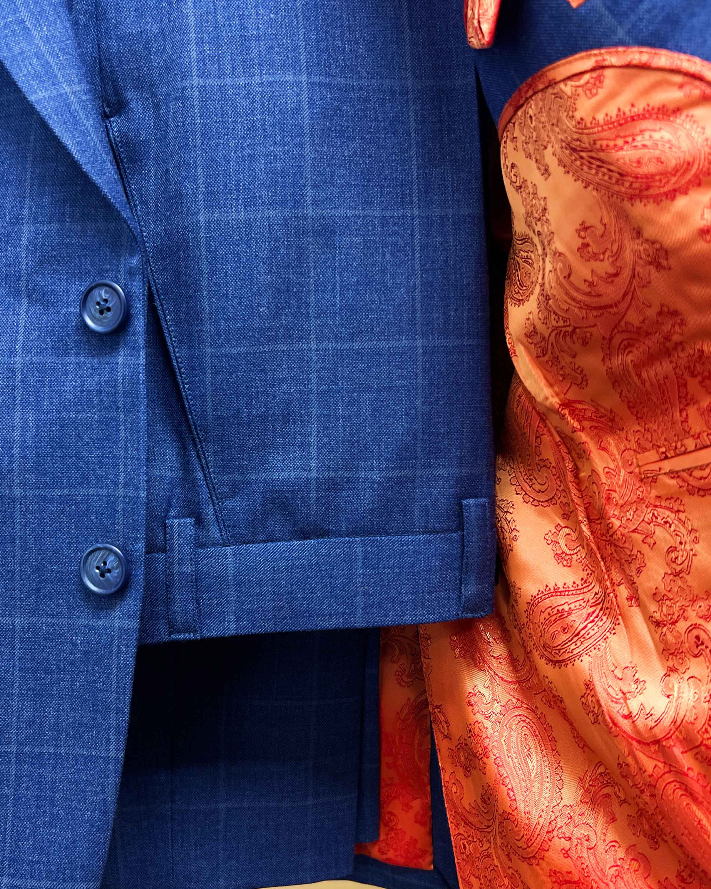 Complete two-piece deep blue windowpane check custom suit displayed on hanger showing jacket and trousers with windowpane pattern