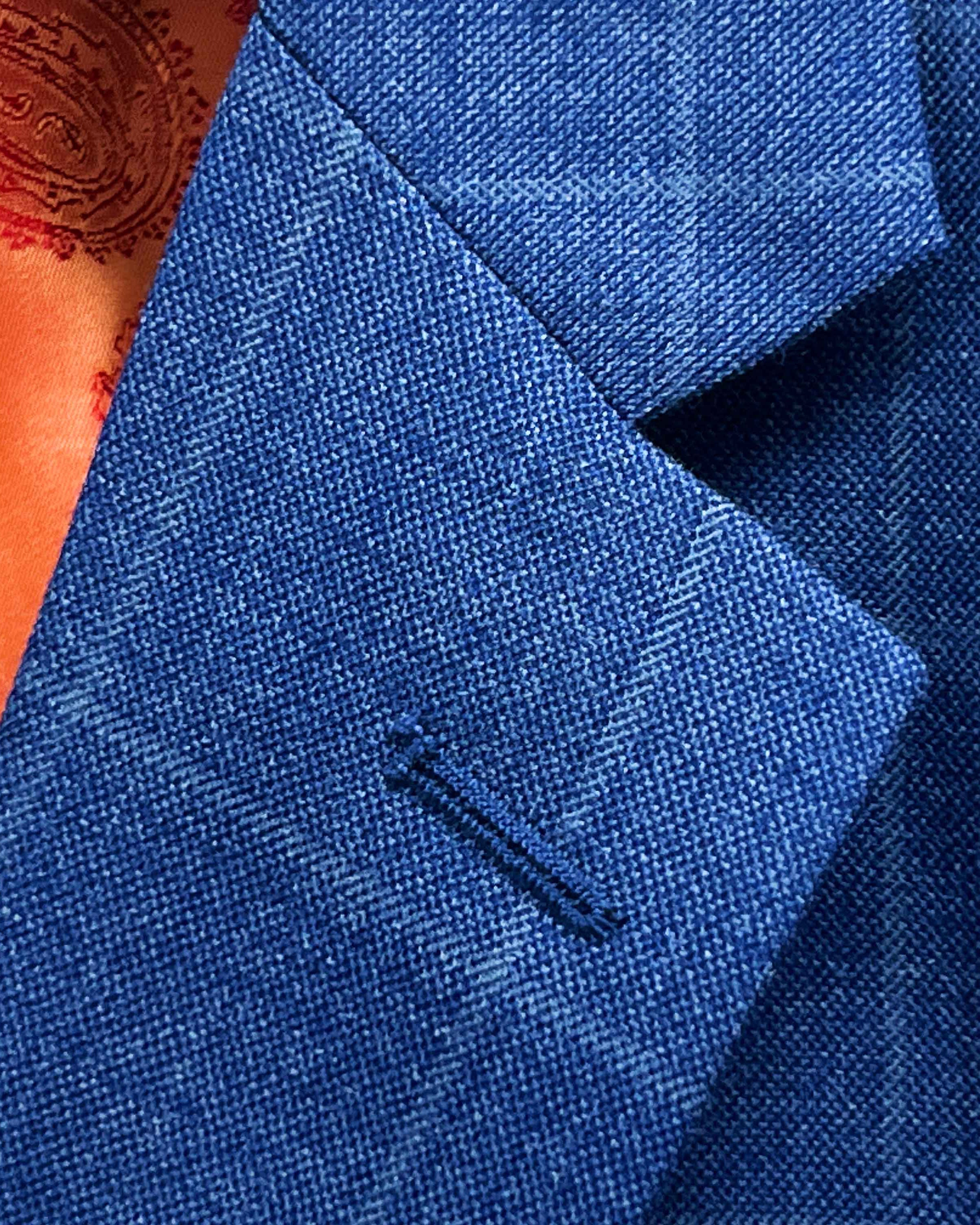 Classic notch lapel detail on deep blue windowpane check suit jacket showing hand pick stitching and windowpane pattern