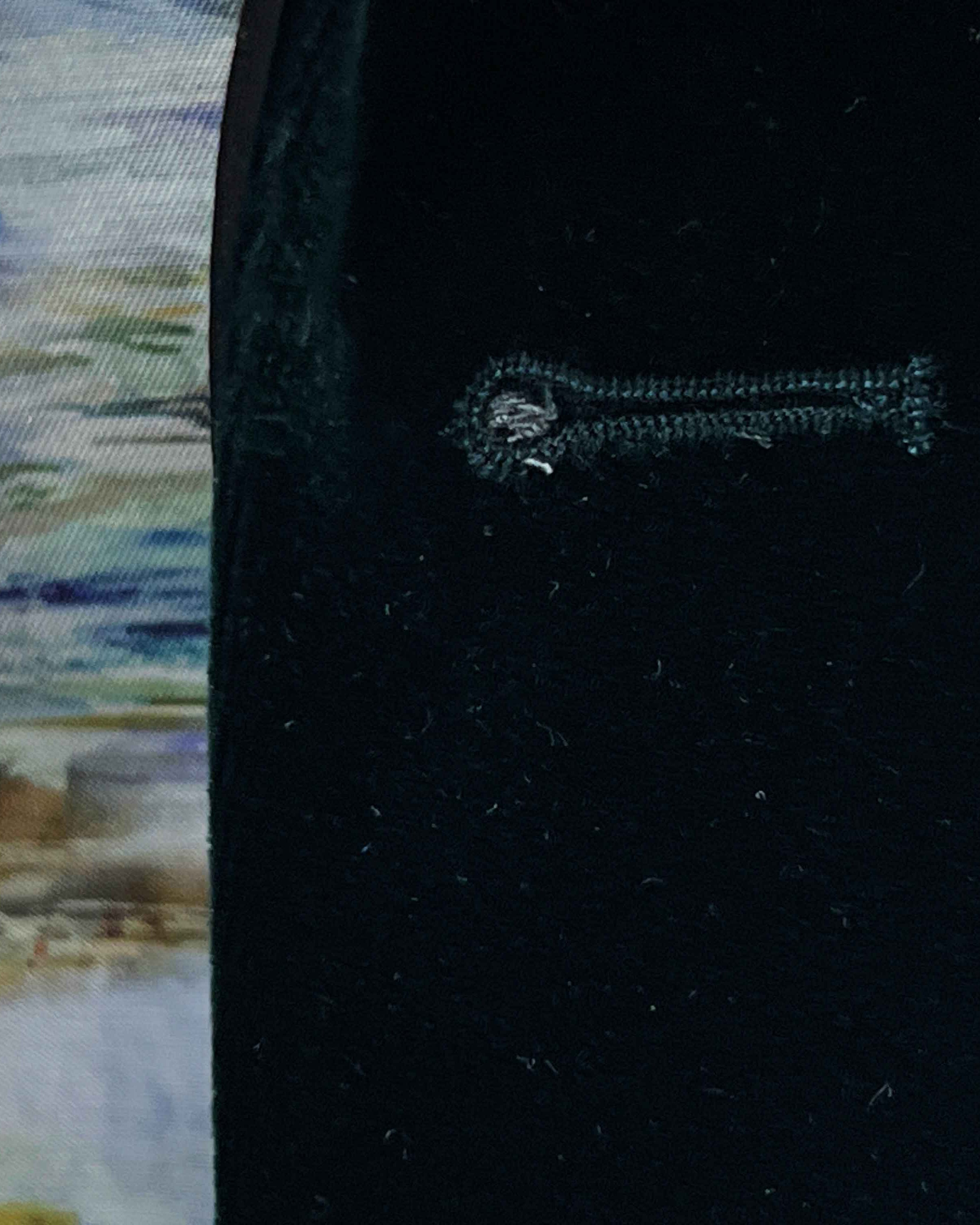 Close-up of a black fabric with an embroidered key design on a blurred background.