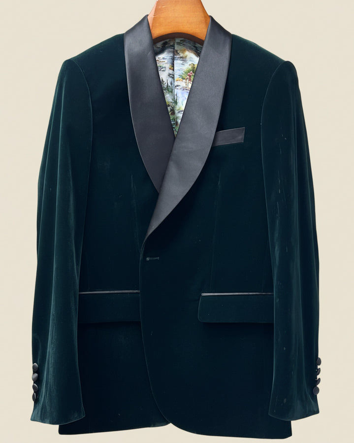 Dark green velvet tuxedo jacket with satin lapels on a beige background