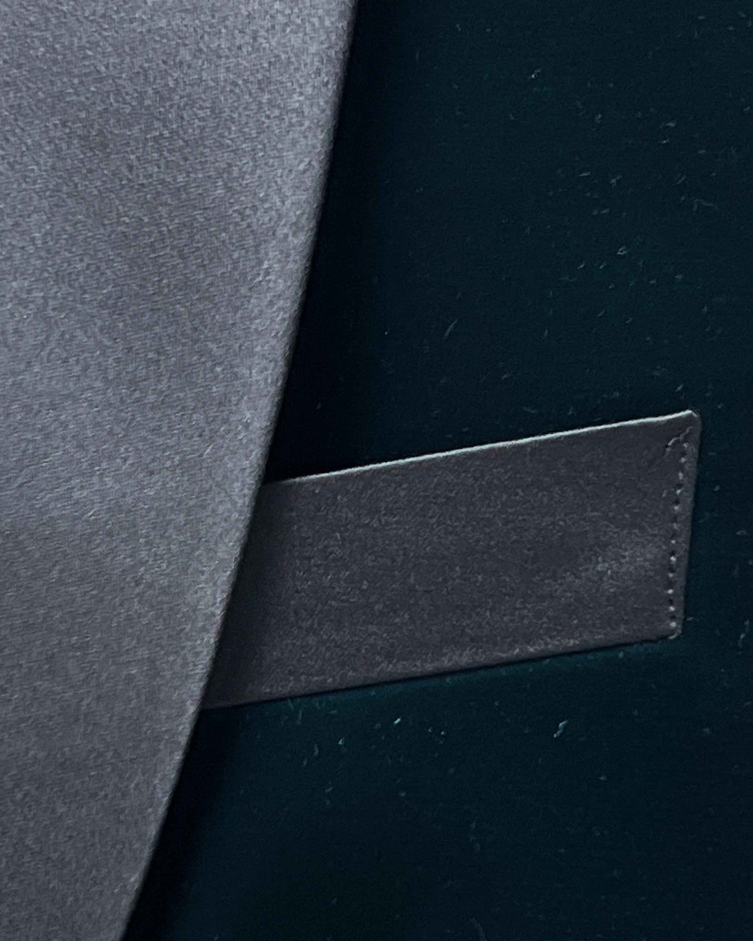 Close-up of a dark gray leather patch on a black background