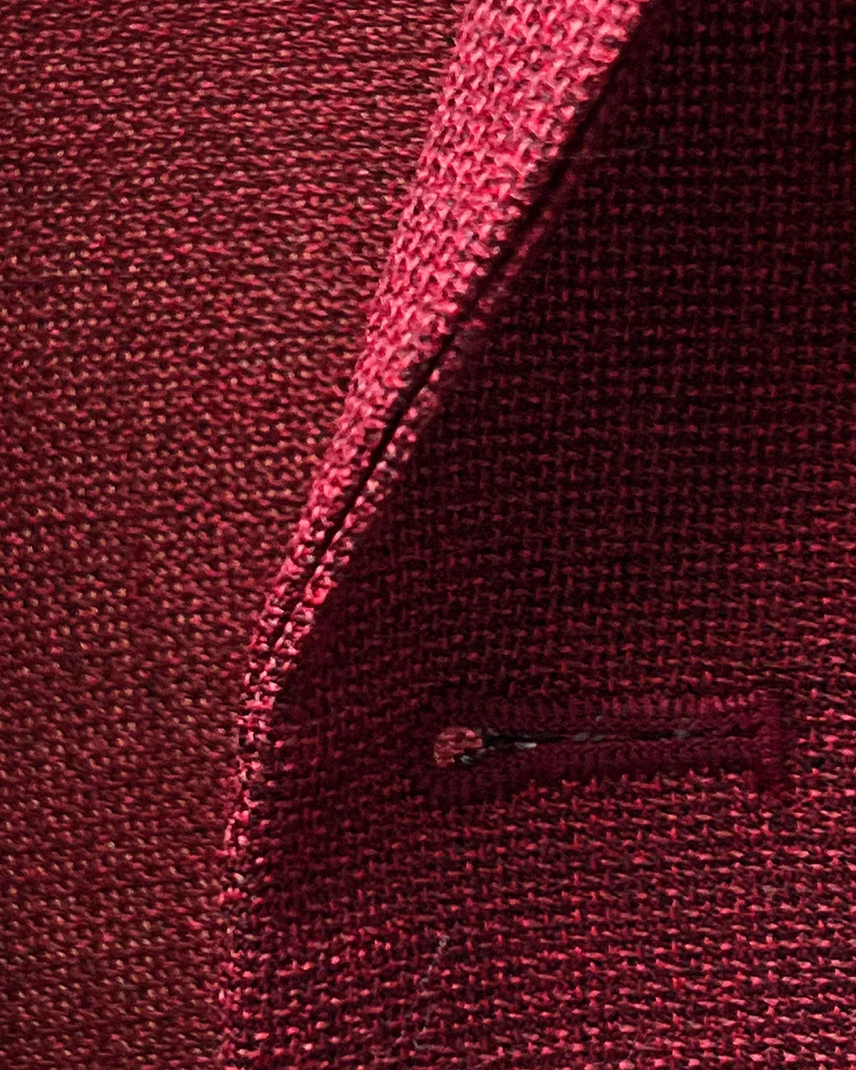 Macro detail of deep red basketweave fabric texture showing the intricate weave pattern and wool fiber quality