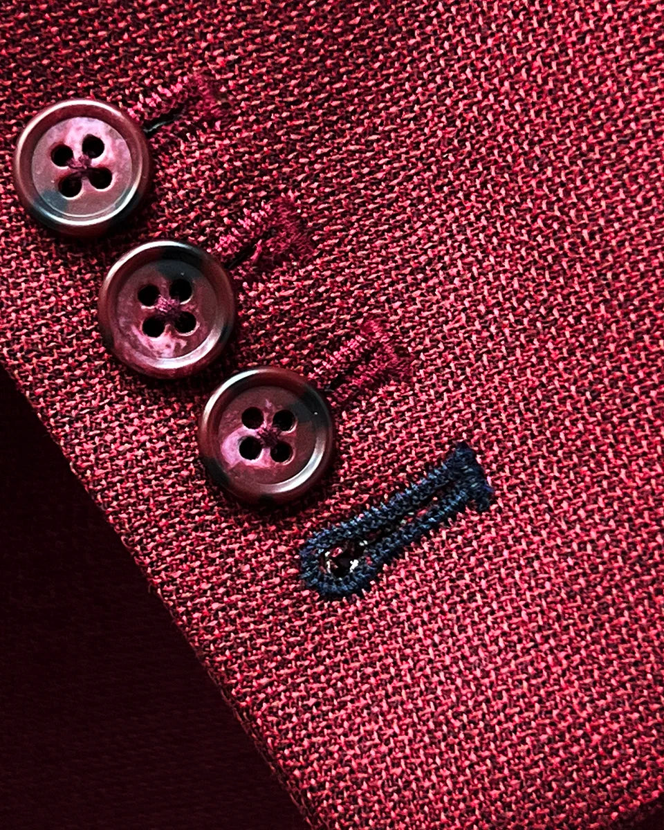 Sport coat jacket sleeve cuff showing functional buttonholes with contrast navy blue accent stitching on deep red basketweave fabric