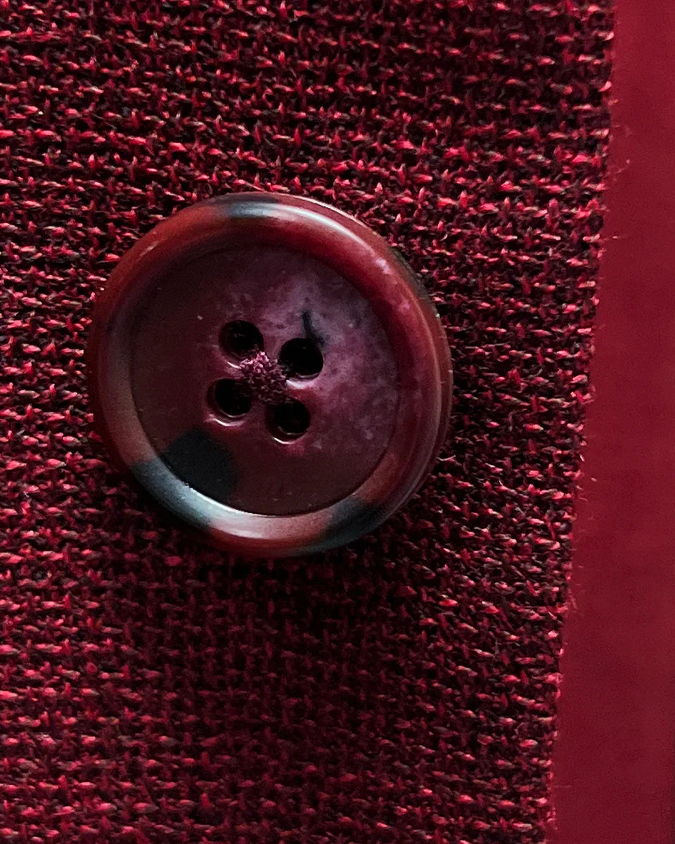 Close-up of dark red horn buttons on deep red basketweave sport coat jacket showing natural marble-like patterns