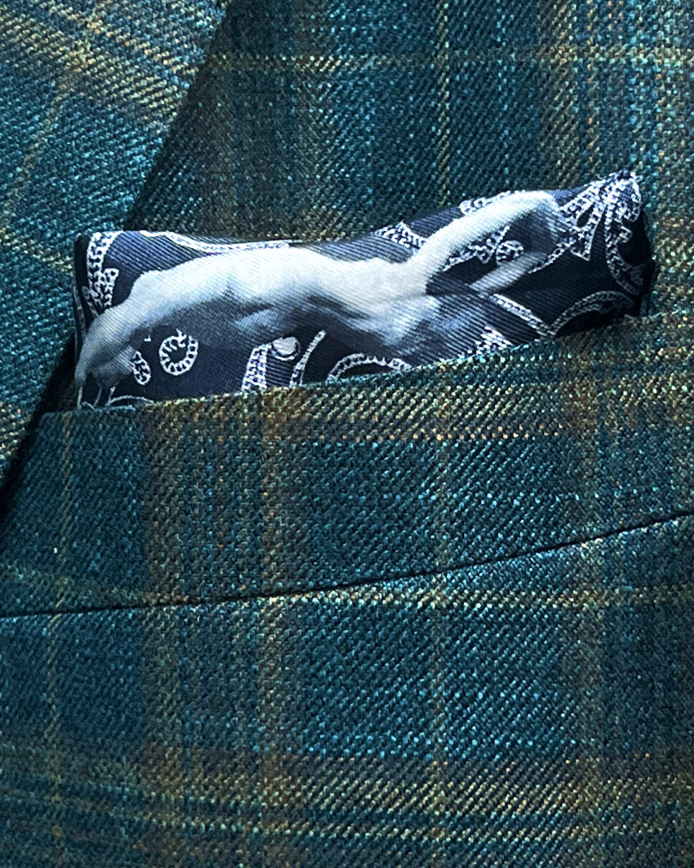 Breast pocket of deep teal green multi check suit jacket with built-in pocket square holder and hand-finished edges