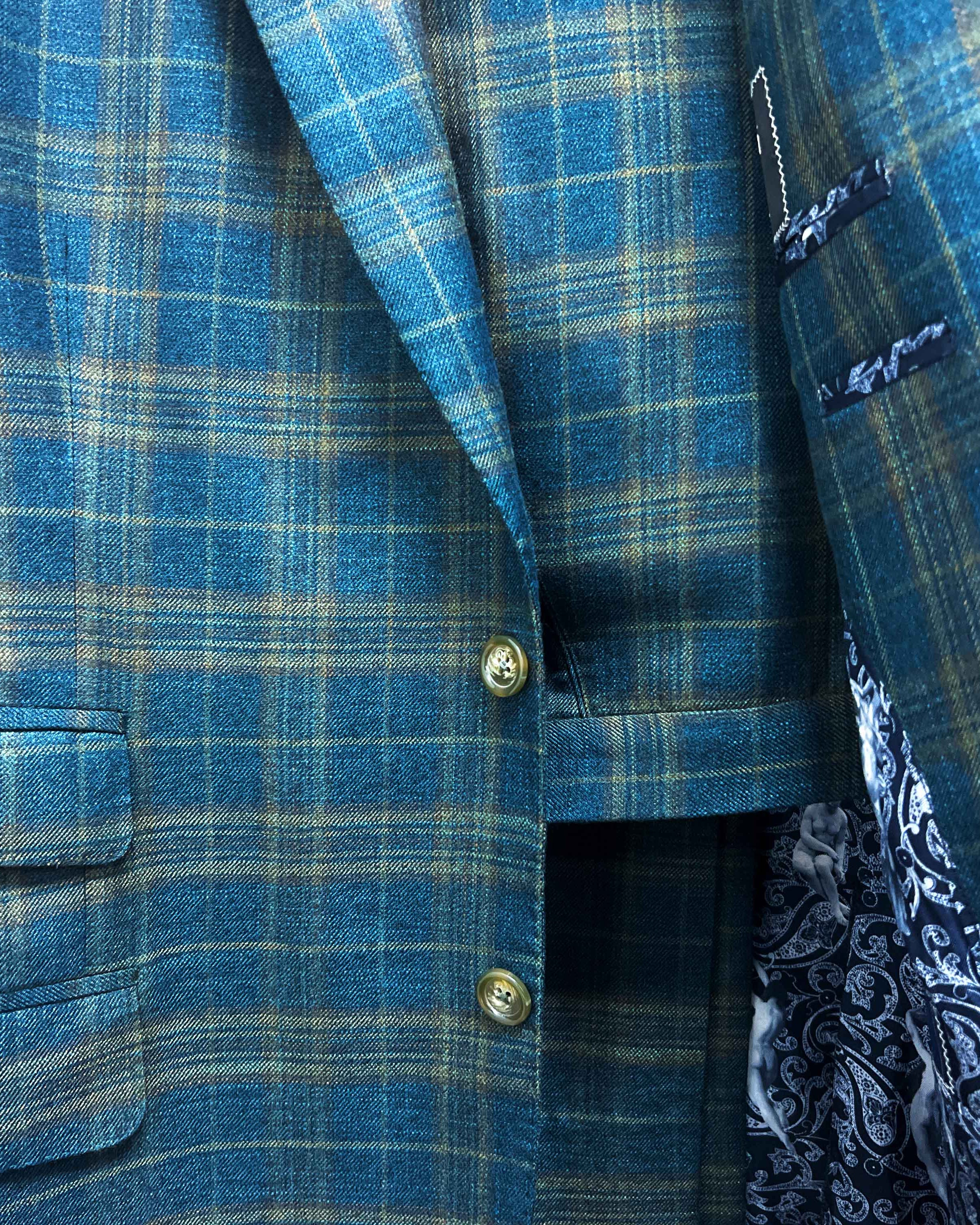 Complete two-piece deep teal green multi check custom suit displayed on hanger showing jacket and trousers with plaid check pattern