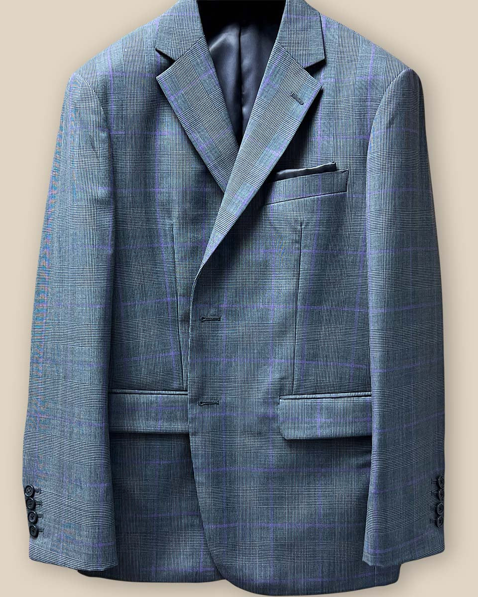 Close-up of grey suit jacket sleeve with purple windowpane pattern, showing functional buttonholes
