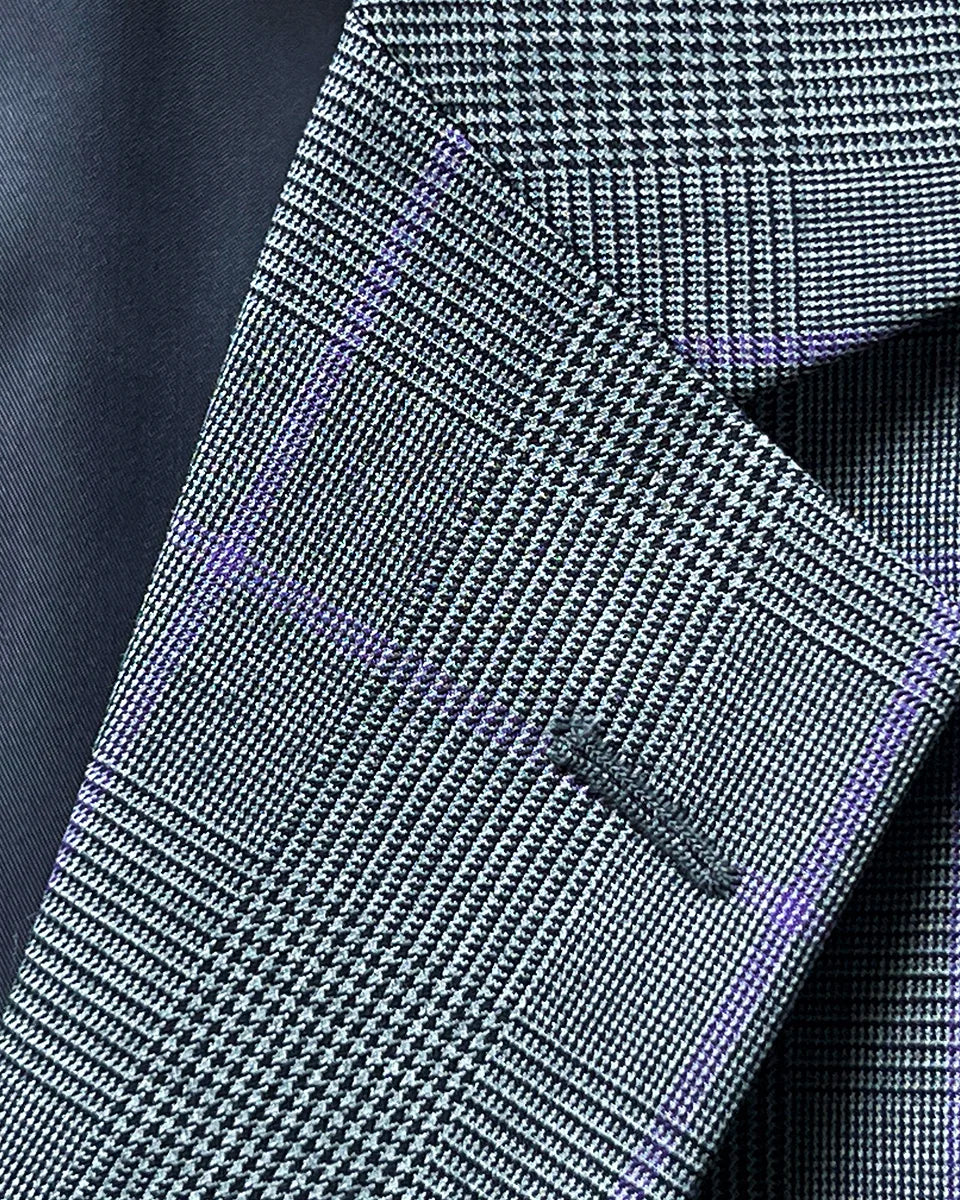 Detailed view of suit jacket's notch lapel, highlighting the Prince of Wales plaid pattern