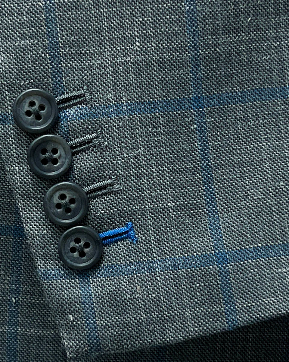 Close-up of the functional sleeve buttonholes on the Westwood Hart grey with medium blue windowpane men's sport coat.
