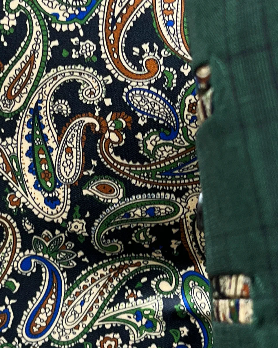 Colorful flash lining detail visible at jacket cuffs and vents in paisley pattern with navy, rust, green and light blue