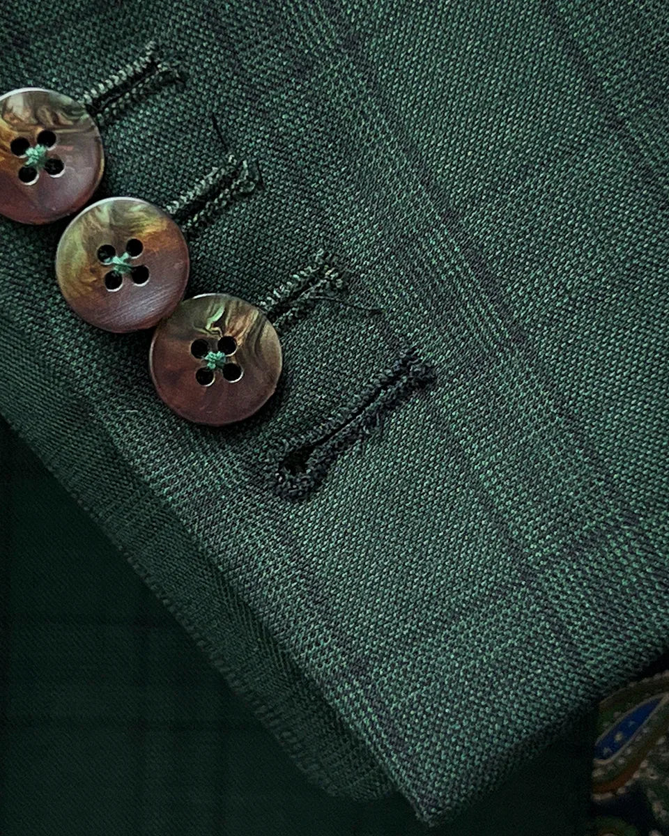 Sport coat jacket sleeve cuff showing functional buttonholes with contrast black accent stitching on hunter green checkered fabric
