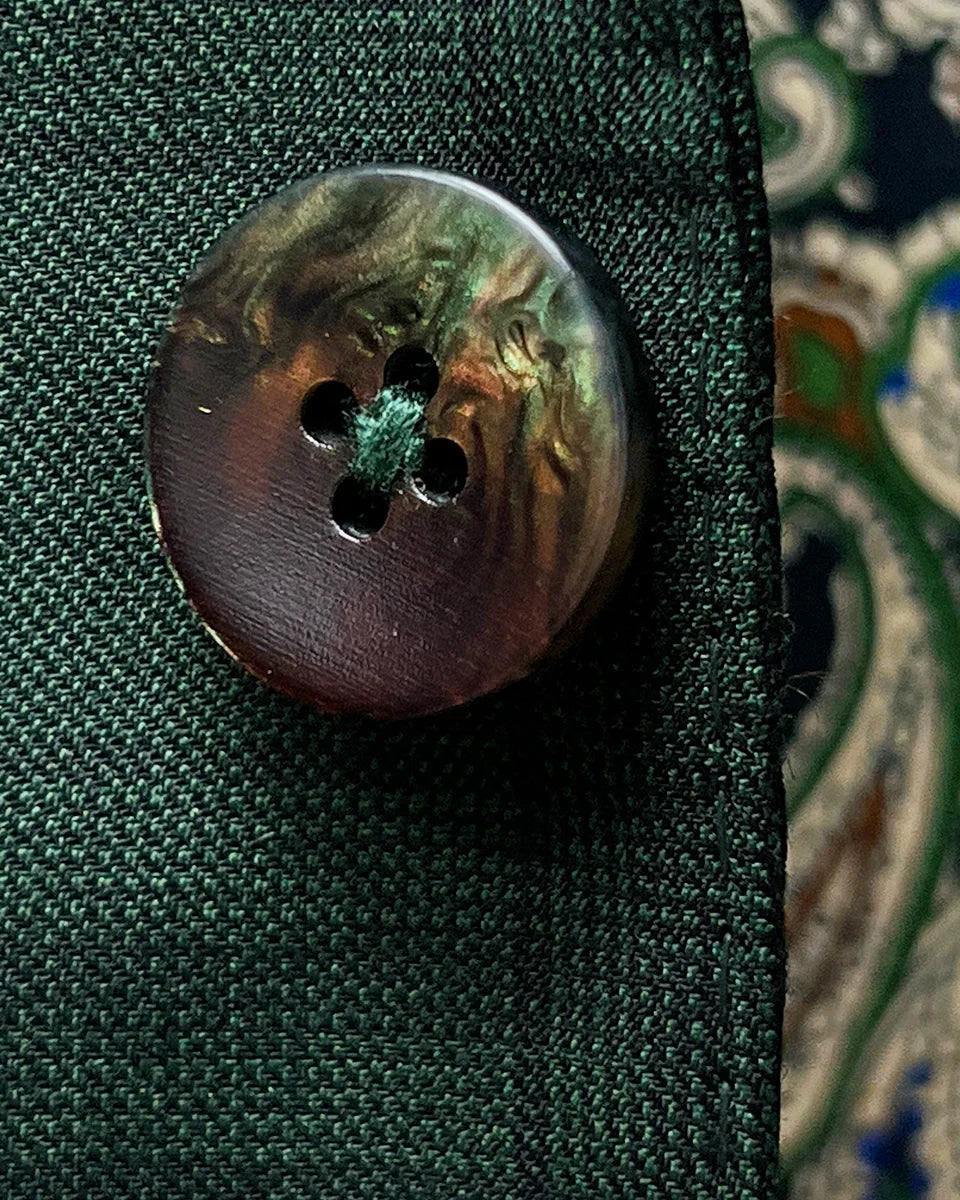 Close-up of walnut brown with green horn buttons showing natural marble-like patterns and rich coloring