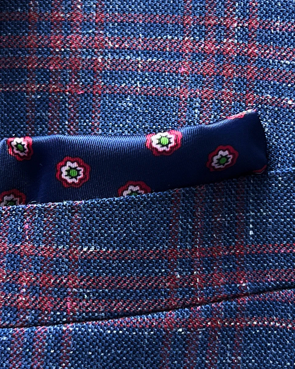 Chest pocket detail with built-in pocket square feature, showing how the navy lining with geometric pattern creates a coordinated pocket display