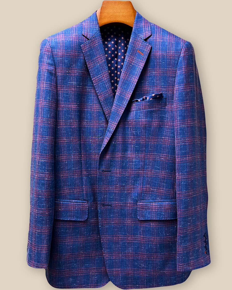 Close-up view of dark berry maroon contrast accent buttonholes on indigo blue windowpane sport coat lapel, showcasing precise hand-stitched details and navy horn button