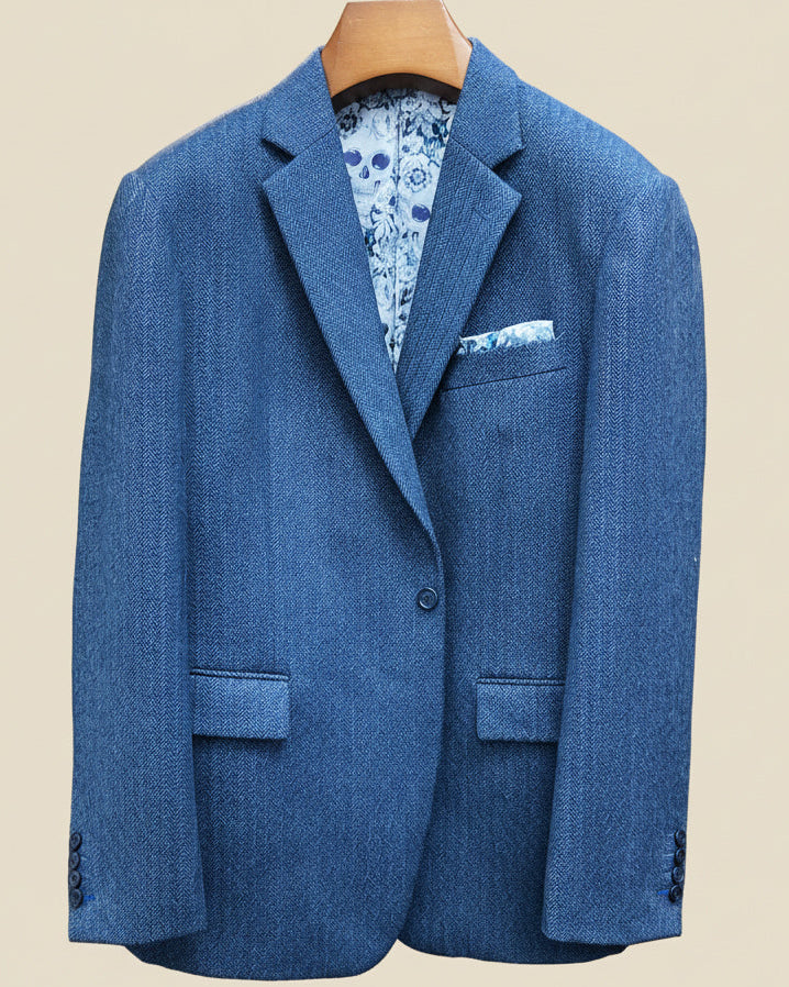 Front button panel of indigo blue herringbone tweed sport coat featuring deep navy blue button and hand pick stitching