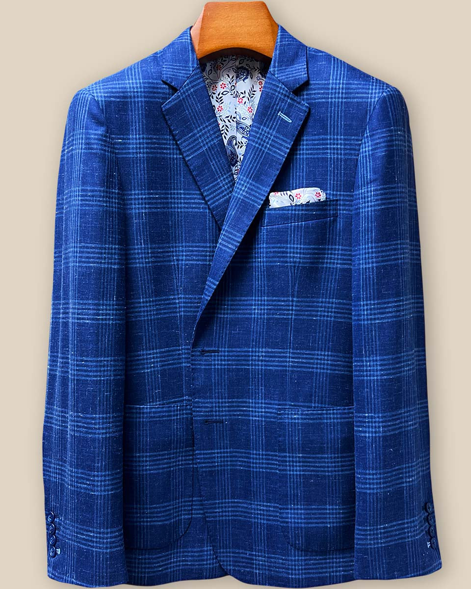 Close-up view of white contrast buttonholes on indigo blue windowpane sport coat lapel, showcasing precision hand-stitched detailing against Westwood Hart linen-wool fabric