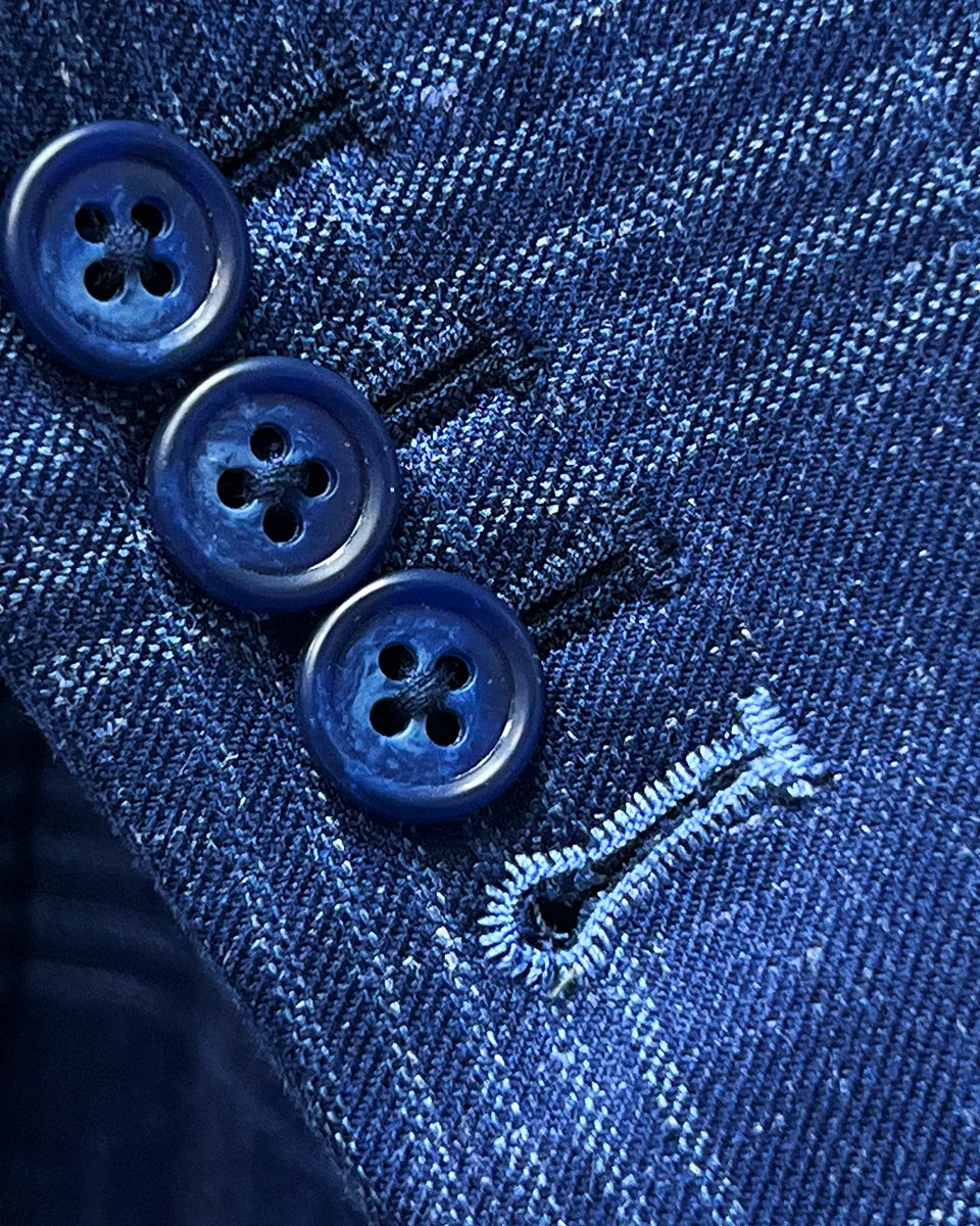 Close-up of functional sleeve buttonholes with white contrast stitching, demonstrating authentic custom tailoring on working sleeve buttons