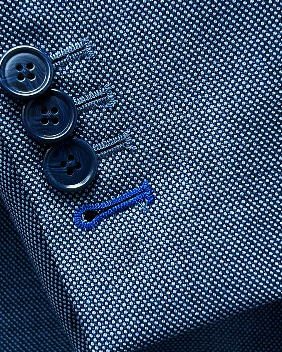 Detail of suit jacket sleeve showing functional buttonholes with navy horn marble buttons